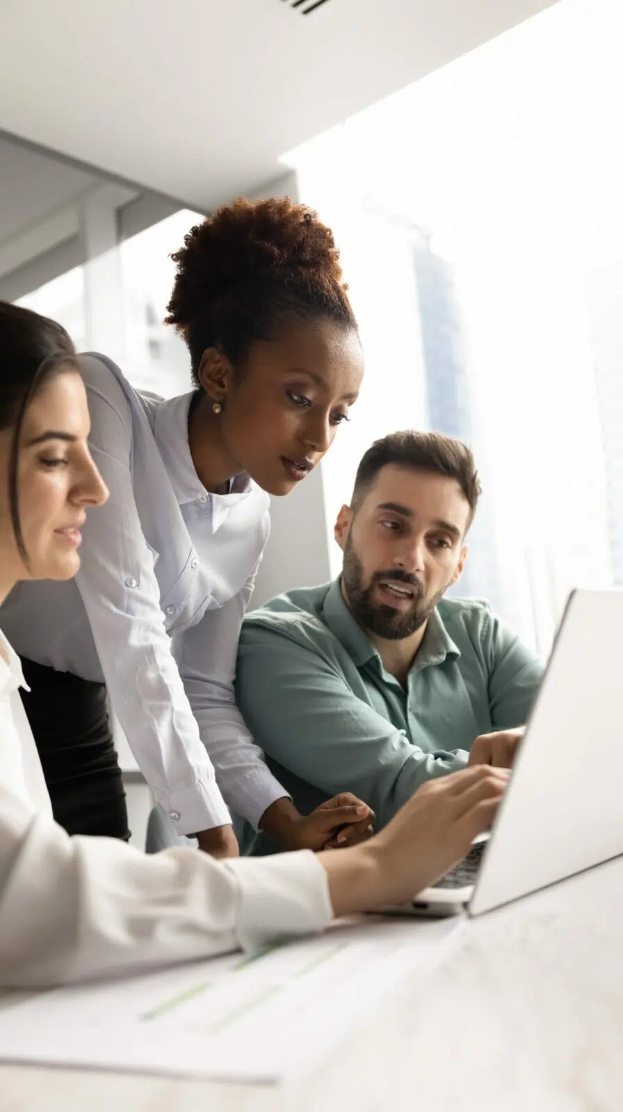 Équipe de responsables marketing travaillant ensemble sur un ordinateur portable